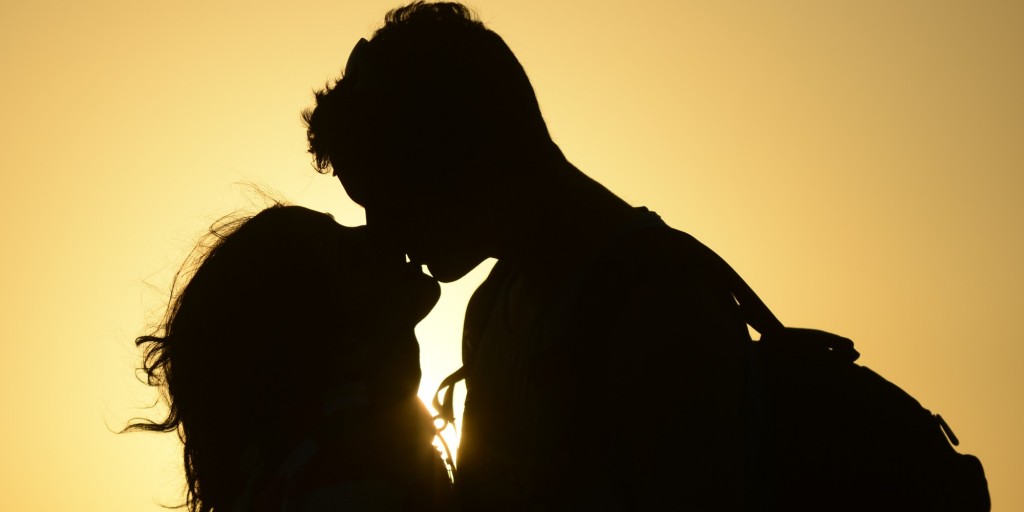 kochankowie całujący się przy zachodzie sońca