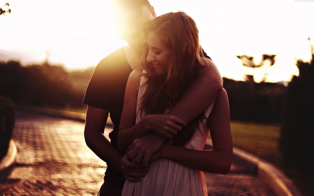 piękna kobieta i meżczyzna przytulają się w promieniach słońca